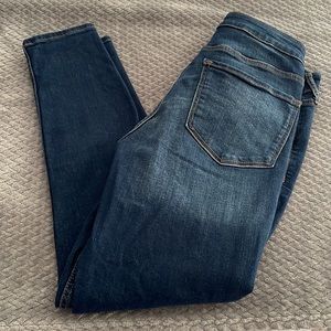 Women’s dark wash MID-RISE rockstar super skinny Jean.